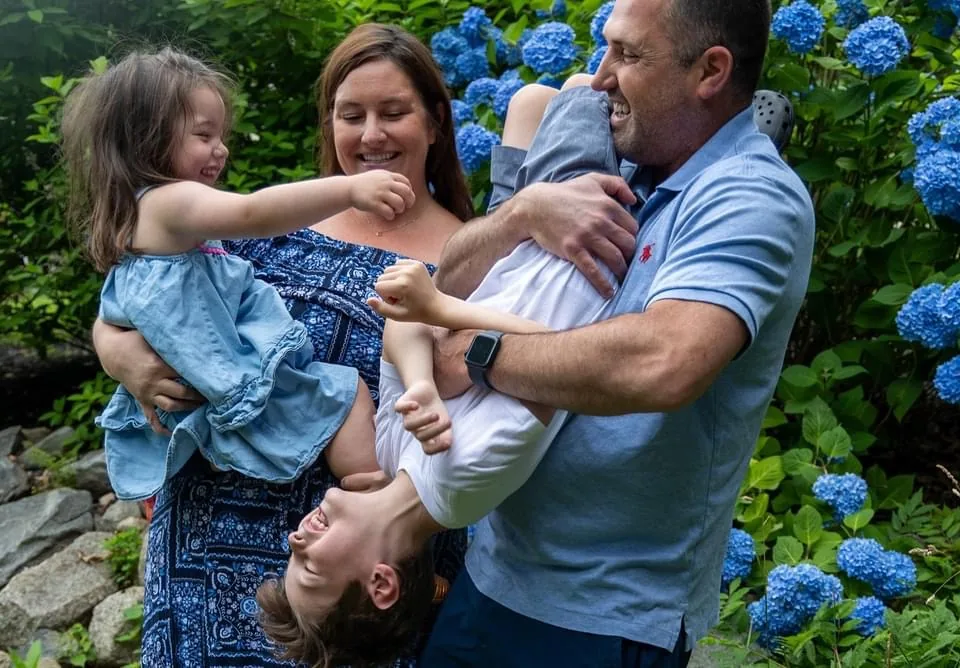 Parents laughing with their two kids outdoors